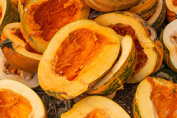 Pumpkin leftovers from a harvest festival in a rural area, showcasing vibrant orange flesh and green rinds during the autumn season