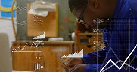 Reviewing smartphone charts, technician in coveralls holding stylus in woodshop, copy space