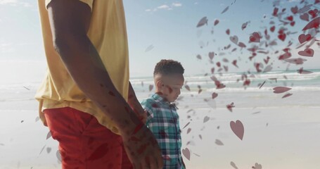 Walking father and son barefoot along wet sand shoreline, with heart-shaped overlays, copy space