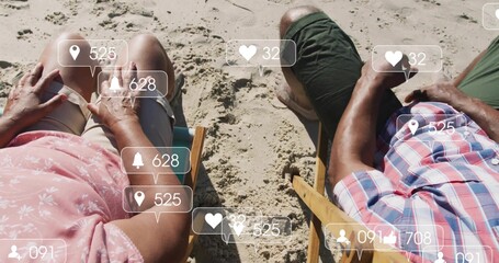 Reclining couple soaking up sunshine on wooden chairs on sandy beach, with floating icon overlays