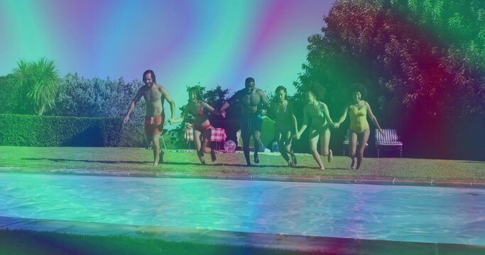 Running friends gripping hands and rushing into backyard pool, with checkered blanket and cooler