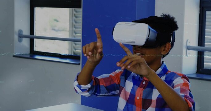 Teenage boy wearing plaid shirt using VR headset in tech lab, with table, windows, partition panel