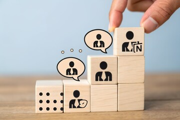 Hand stacking wooden blocks with people icons representing career growth and communication