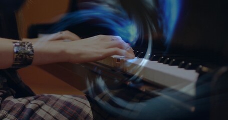 Playing pianist's hands moving over piano keyboard at music studio, with metallic cuff, plaid skirt