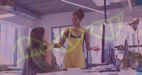 Collaborating colleagues reviewing computer screen in modern office, with lamp and papers