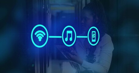 Technician using tablet monitoring server LEDs showing turquoise icons in datacenter, copy space © vectorfusionart