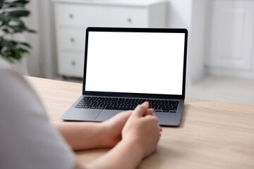 Fototapeta premium Woman working with laptop at wooden table indoors, closeup. Mockup for design