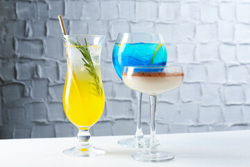 Glasses of tasty cocktails on white table