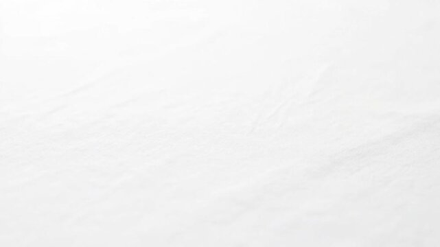 Close-up of a white textured surface, possibly fabric or paper, with subtle variations in tone.