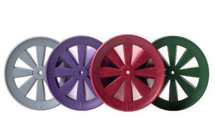 Fototapeta premium Four colorful spoked wheels with a central hub, standing in a row against a black backdrop