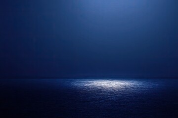 Dark, atmospheric ocean illuminated by a centered light source creating a shimmering effect