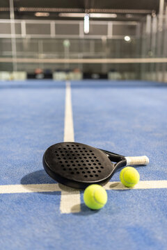 Paddle tennis racket nd balls in court