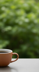 A close-up of a ceramic mug filled with hot black coffee, set against a blurred green natural background
