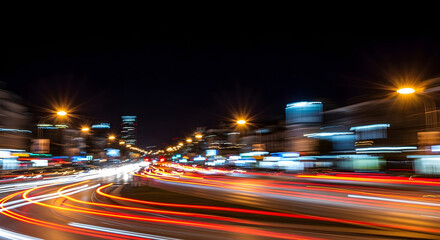 Long exposure photograph of city street at night with vibrant light trails from moving vehicles and blurred buildings.