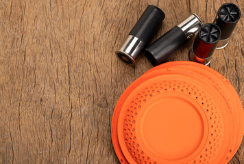 Flying clay pigeon target with shot gun bullet shell on wooden background , Gun shooting game
