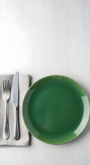 Elegant green plate with fork and knife set on a neutral background, perfect for food presentation and dining imagery