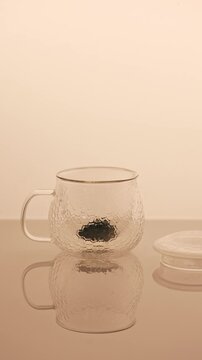 Minimal tea brewing ritual in glass cup, calm aesthetic video.  Pouring hot water in glass cap with black tea. 4K  video.