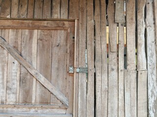 This rustic wooden door and plank wall create a natural, vintage texture perfect for backgrounds, product displays, architecture themes, or rural lifestyle content.