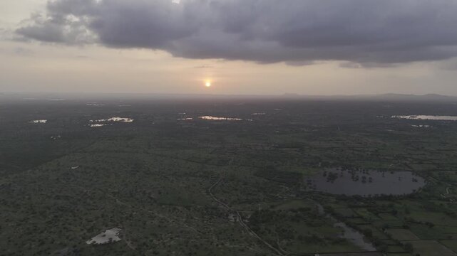 Aerial view of a pond near Padanga village in Ajmer, Rajasthan during monsoon, showing reflections of trees in water, lush green fields, and a forest in background with Ber, Ker, Babool, Rohida