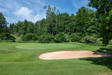 Golfplatzgr&uuml;n mit Sandbunker und Harke