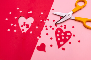 flat lay of scissors and red and pink paper cutouts of circles and hearts against red and pink paper; Valentine's day crafting 