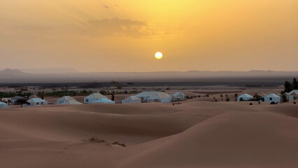 A trip to Sahara desert in Morocco. Beautiful 
african travel photo. Sandy landscapes, famous hotel, 
dunes, and nature. Summer vacation in arab country.