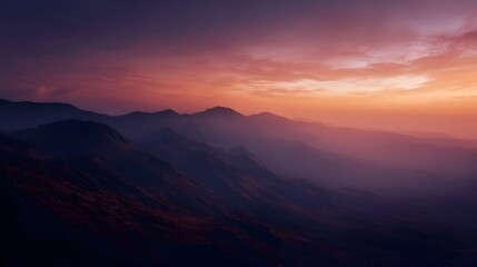 Majestic mountain range at dusk with a dramatic orange and purple sky
