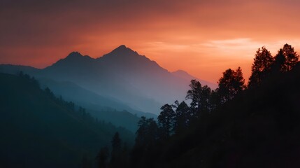 Naklejka premium Majestic mountain ranges bathed in the warm glow of a dramatic sunset sky with atmospheric mist