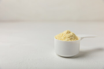 Protein powder. A spoonful of protein powder on a table. Different flavors of whey protein powder. Sports nutrition concept. Gym. Amino acid food supplement, creatine powder. Copy space.