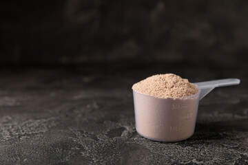 Protein powder. A spoonful of protein powder on a table. Different flavors of whey protein powder. Sports nutrition concept. Gym. Amino acid food supplement, creatine powder. Copy space.