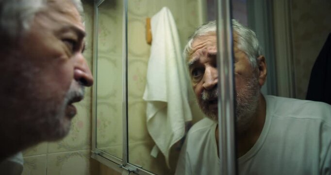 Older man leaning close to mirror, intense gaze filled with focus and reflection, examining his face with a mixture of curiosity and deep contemplation