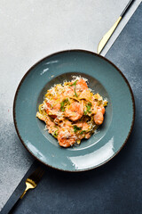 Italian pasta with shrimp and parmesan cheese. In a plate. Restaurant dish. Close up.