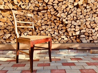 Vintage Wooden Chair Against Firewood Stack - for autumn and countryside design themes