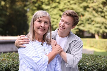 Obraz premium Family portrait of smiling mother and her son outdoors