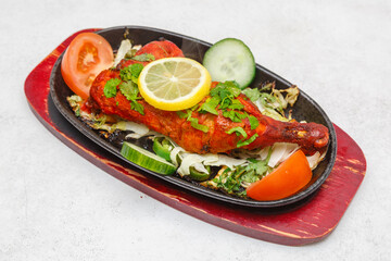 Poulet Tandoori – plat indien traditionnel, poulet mariné aux épices et grillé au tandoor (four indien). Morceaux de poulet marinés dans un mélange d’épices, de yaourt et de citron, grillés au tandoor
