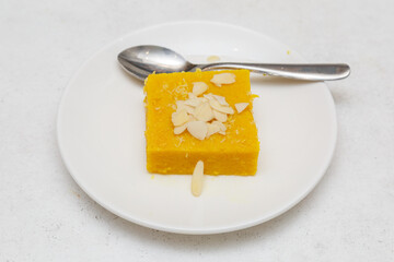 Suji Halwa – dessert traditionnel indien à base de semoule, cuit avec du sucre, du ghee et des épices, saupoudré de noix de coco, photographie culinaire. Dessert populaire en Inde.
