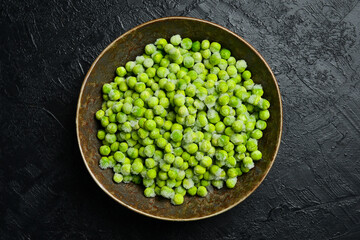Close-up of a bowl of frozen green peas. Preparing frozen vegetables for the winter.