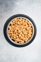 Dog food in a silver bowl. Dry animal feed in a bowl close up.
