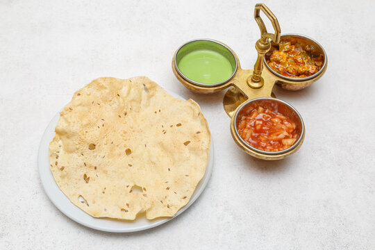 Trois sauces indiennes &ndash; verte, piquante et sucr&eacute;e, servies avec papadum, galette indienne frite &agrave; base de farine de haricots urd