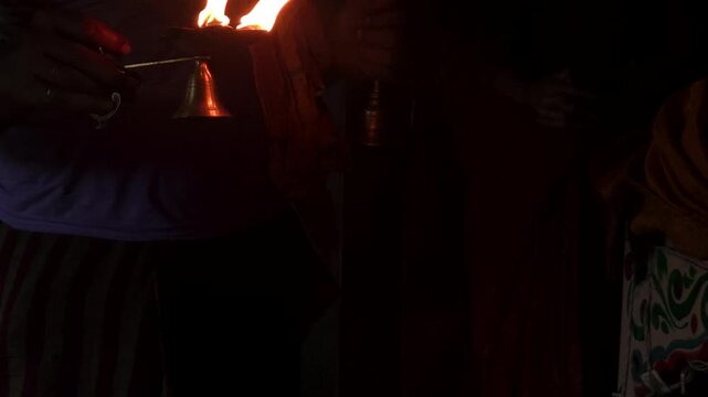 Traditional Hindu Aarti ceremony featuring a glowing oil lamp (Aarti Diya) with multiple flames. The sacred ritual is performed as an offering to the deity during temple worship in India