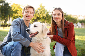 Happy couple with their adorable golden retriever dog in park