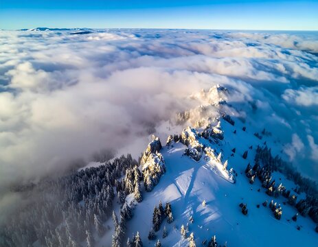 Aerial view of snowy mountain peaks emerging above a sea of clouds