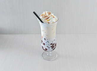 Snow White Red Bean Drink Layered with Sweet Iced Dessert with Whipped Cream and Cocoa Dust in glass side view of hong kong drink