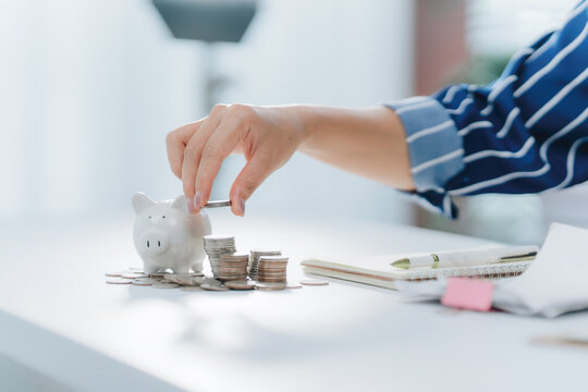 Investing in Savings: A person is diligently saving and investing a coin into a piggy bank, symbolizing financial growth and planning for the future.