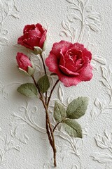 Beautifully crafted pink roses made of fabric against a textured white background, showcasing intricate details and artistry