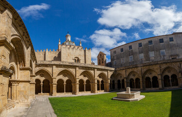 A panoramic view of a sunlit courtyard with a central fountain
