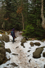 Fototapeta premium Girl hiking and taking photos in Aigüestortes National Park in the Pyrenees, Spain