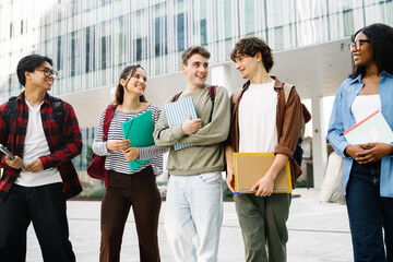 Group of diverse casual students walking talking after University classes at campus