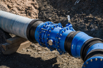 Closeup of blue industrial pipe connection outdoors.