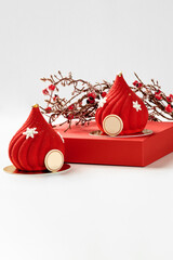 Two red christmas mousse cakes with snowflakes decoration and braun family logo